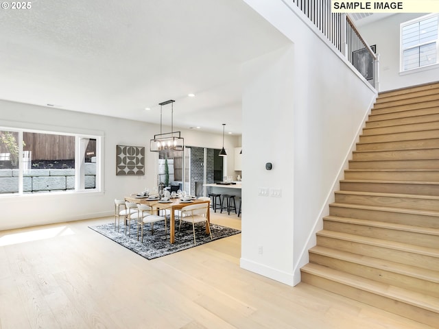 dining area with wood-type flooring and a chandelier