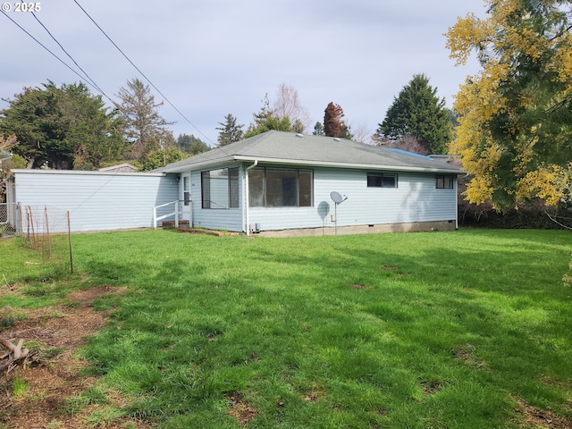 back of house with a yard, crawl space, and fence