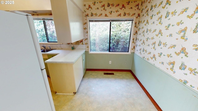 interior space with plenty of natural light, a sink, and wallpapered walls