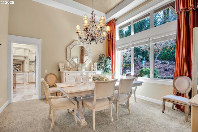 dining room featuring light colored carpet, a high ceiling, an inviting chandelier, and a healthy amount of sunlight