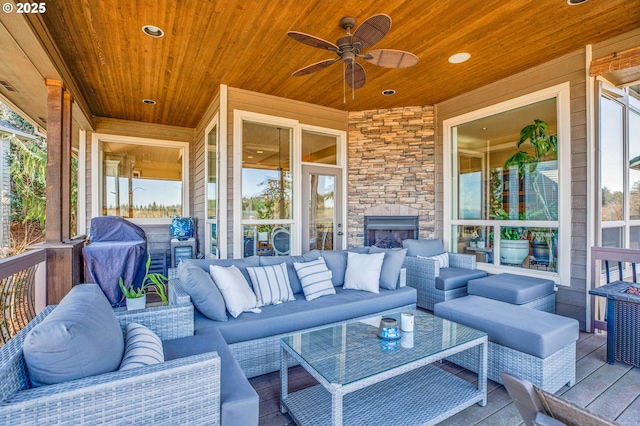 view of patio featuring area for grilling, an outdoor living space with a fireplace, and a ceiling fan