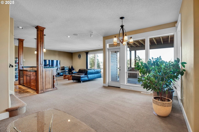 living area with light carpet, a textured ceiling, and baseboards