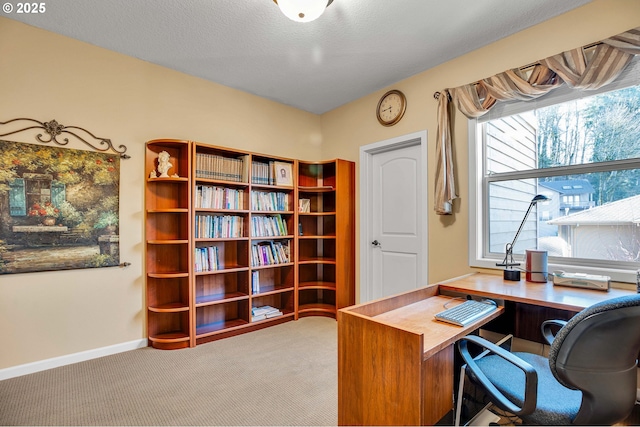 carpeted office with baseboards and a textured ceiling