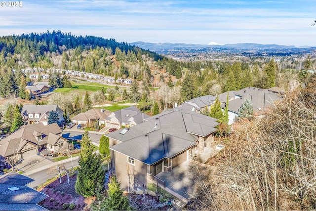 birds eye view of property with a residential view, a mountain view, and a wooded view