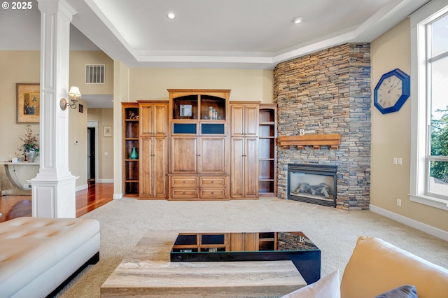 living area featuring visible vents, baseboards, carpet, and ornate columns