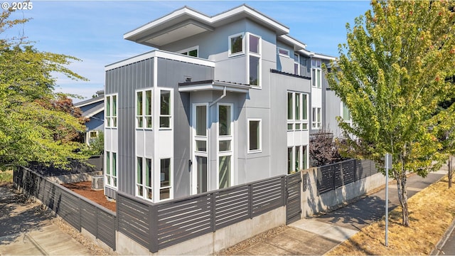 contemporary home featuring fence