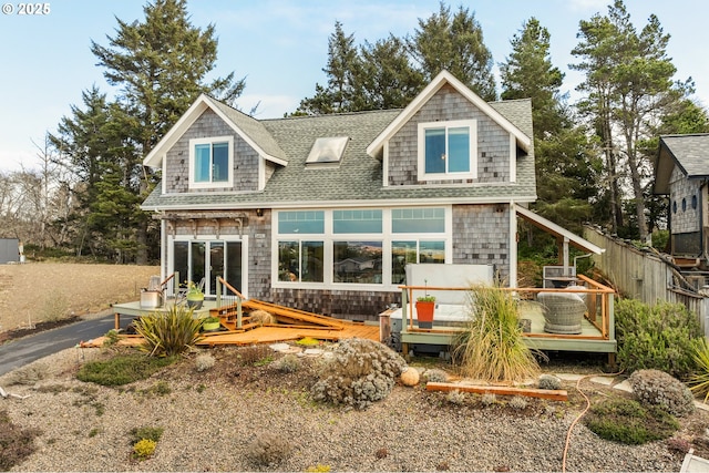 rear view of house with a shingled roof and a deck