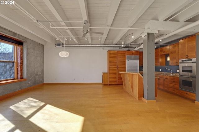 kitchen featuring stainless steel appliances, brown cabinetry, a ceiling fan, and light wood-style flooring