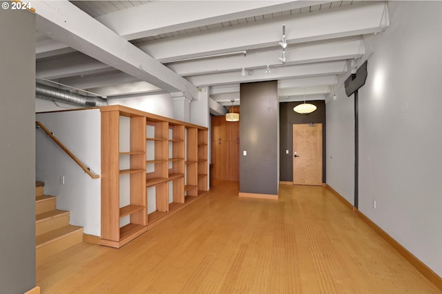 basement with wood finished floors, baseboards, and stairs