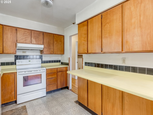 660 Barton Ave, Gladstone, OR 97027 - kitchen featuring electric range, under cabinet range hood, light countertops, and brown cabinetry