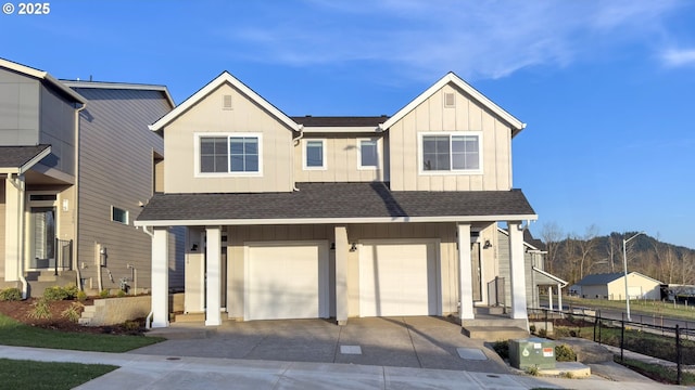 view of front of home featuring fence, an attached garage, a shingled roof, concrete driveway, and board and batten siding