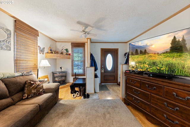 540 Kesling St, Harrisburg, OR 97446 - living room featuring crown molding, light wood-type flooring, a ceiling fan, a textured ceiling, and a wood stove