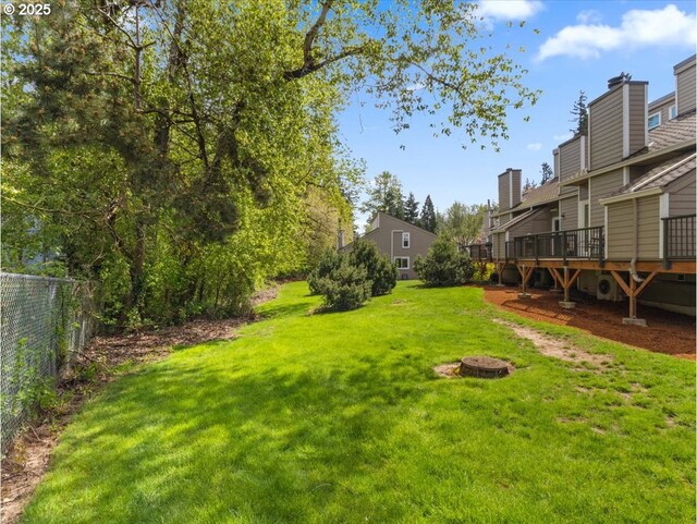 view of yard featuring a wooden deck and fence