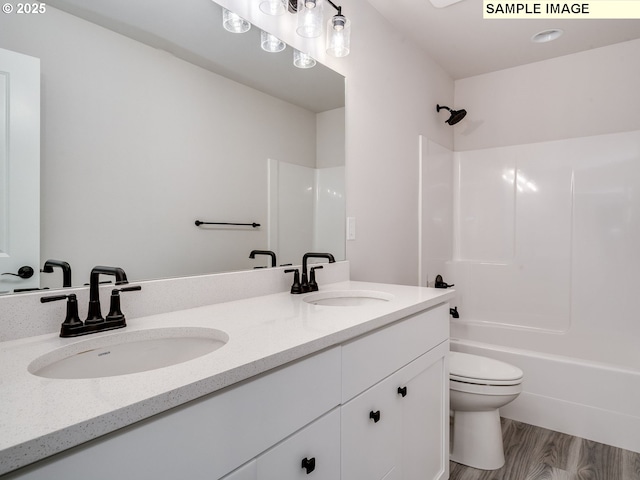 full bathroom featuring bathtub / shower combination, hardwood / wood-style floors, vanity, and toilet