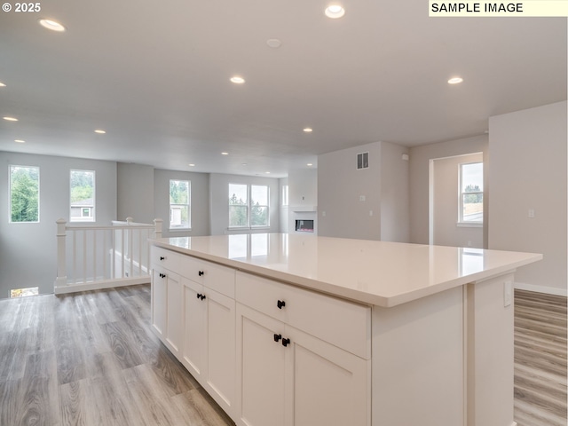 kitchen featuring light wood-type flooring, white cabinetry, and a kitchen island