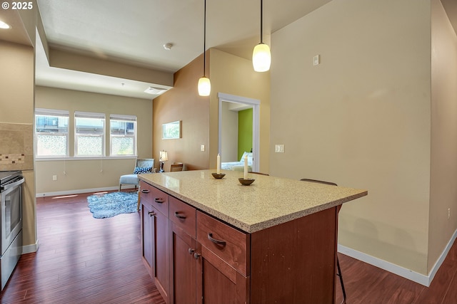 13885 SW Meridian St Unit 135, Beaverton, OR 97005 - kitchen with dark wood-style flooring, decorative light fixtures, a kitchen island, and a breakfast bar
