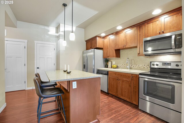 13885 SW Meridian St Unit 135, Beaverton, OR 97005 - kitchen with appliances with stainless steel finishes, dark wood-type flooring, a center island, and backsplash