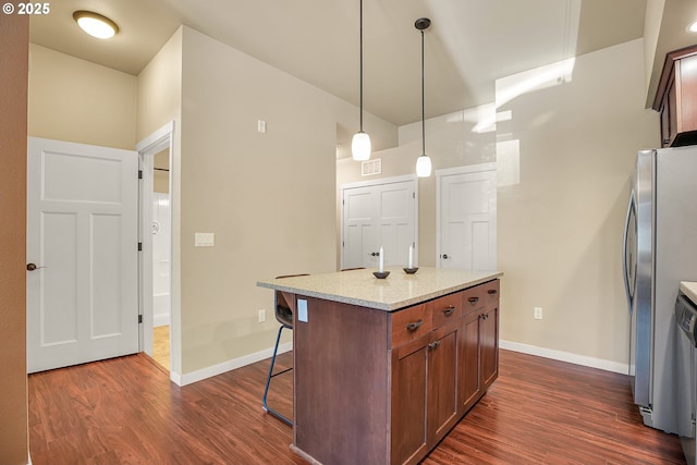 13885 SW Meridian St Unit 135, Beaverton, OR 97005 - kitchen featuring freestanding refrigerator, a kitchen bar, dark wood-style flooring, and hanging light fixtures
