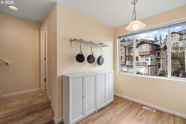 unfurnished dining area with stairway, baseboards, visible vents, light wood finished floors, and recessed lighting