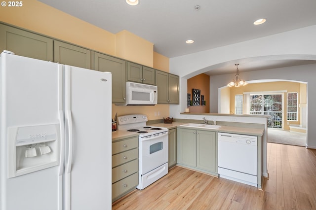 kitchen with a notable chandelier, a sink, white appliances, arched walkways, and green cabinets