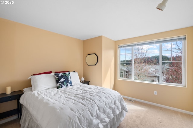 bedroom featuring visible vents, baseboards, and carpet