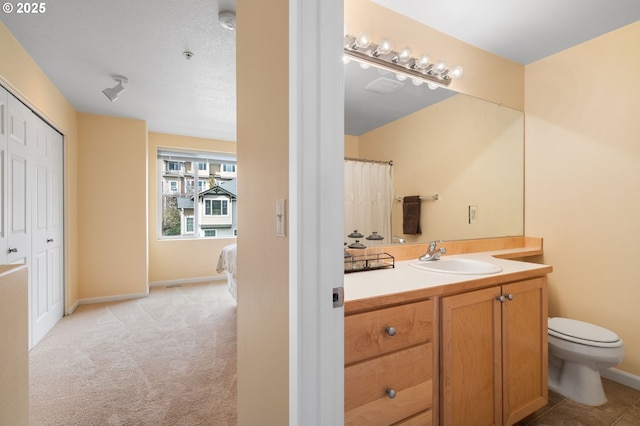 full bathroom featuring toilet, vanity, and baseboards