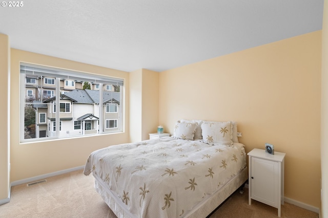 carpeted bedroom with visible vents and baseboards