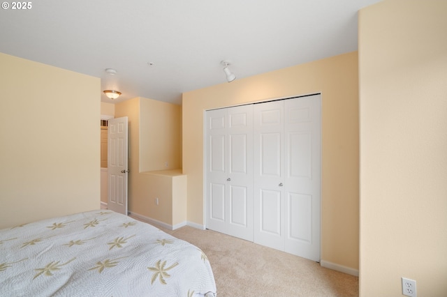 bedroom featuring carpet, a closet, and baseboards