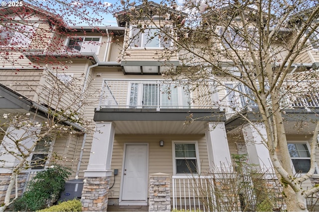 view of front of property featuring a balcony and stone siding