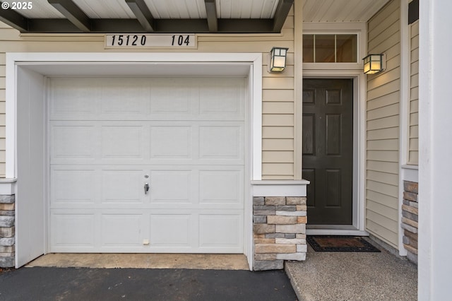 property entrance with stone siding and a garage