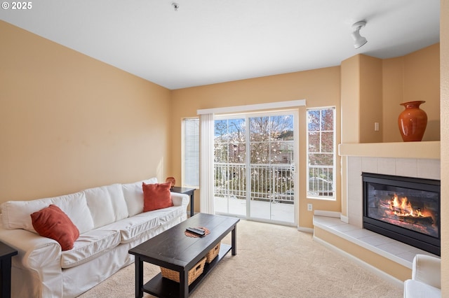 living room with carpet and a tile fireplace