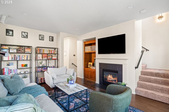 842 NE Rothbury Ave, Hillsboro, OR 97124 - living room featuring arched walkways, dark wood finished floors, recessed lighting, stairway, and a fireplace
