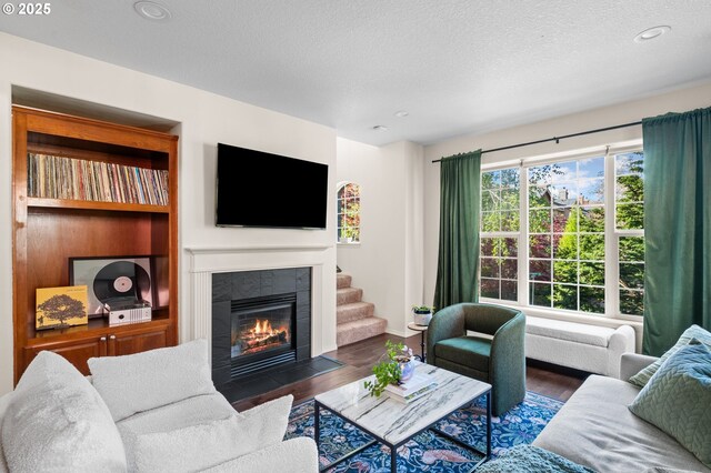 842 NE Rothbury Ave, Hillsboro, OR 97124 - living area with wood finished floors, a textured ceiling, a tiled fireplace, baseboards, and recessed lighting