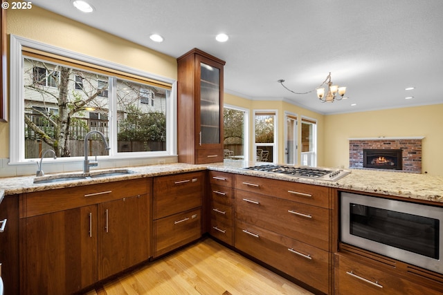 kitchen featuring a sink, built in microwave, and light stone counters