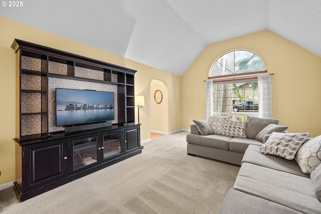 carpeted living room featuring baseboards and lofted ceiling