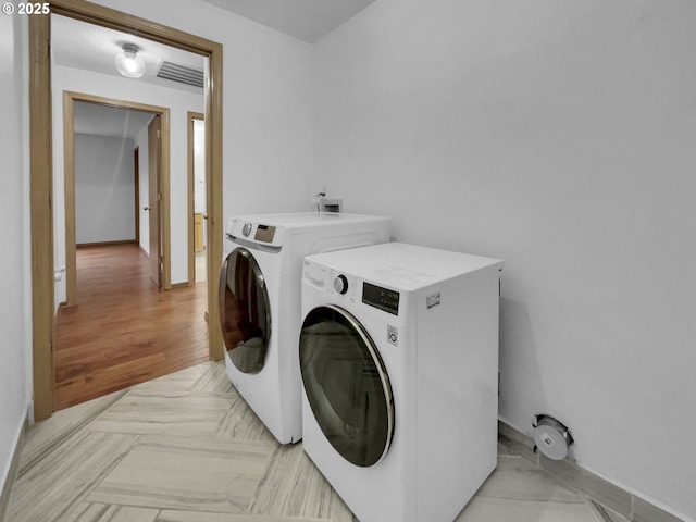 laundry area with baseboards, visible vents, laundry area, and washer and dryer
