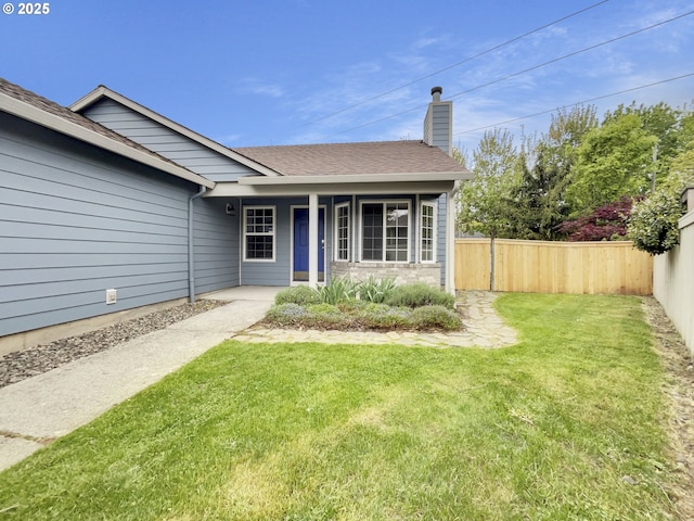single story home with fence, a shingled roof, a front yard, a chimney, and covered porch