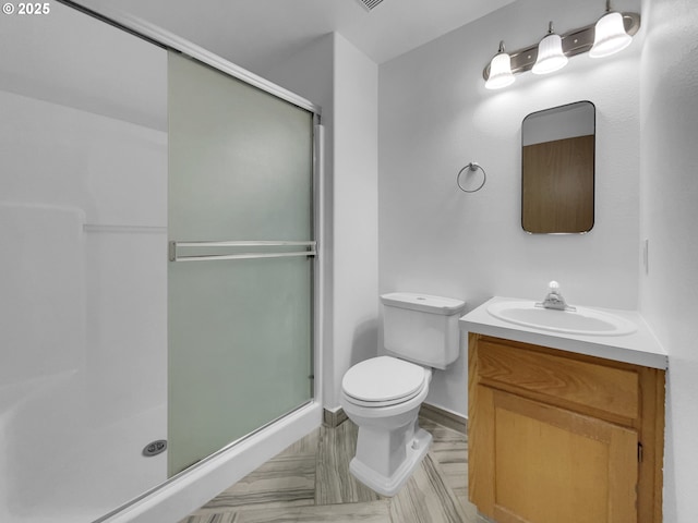 full bathroom with vanity, a stall shower, and toilet