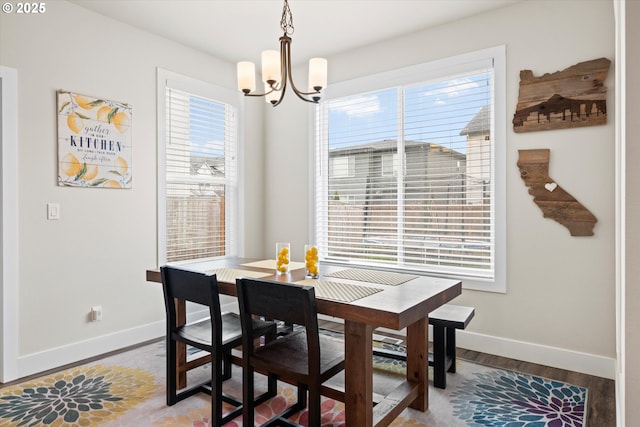 dining space featuring hardwood / wood-style flooring, a wealth of natural light, and a chandelier