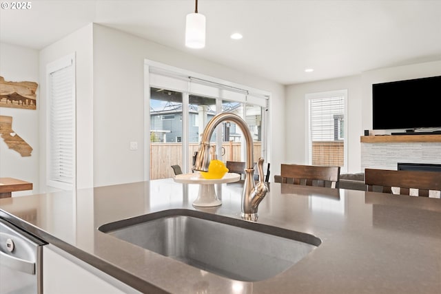 kitchen with pendant lighting, a fireplace, and sink