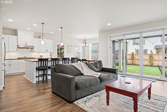 living room featuring a notable chandelier and light wood-type flooring