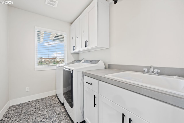laundry area featuring sink, washer and clothes dryer, and cabinets
