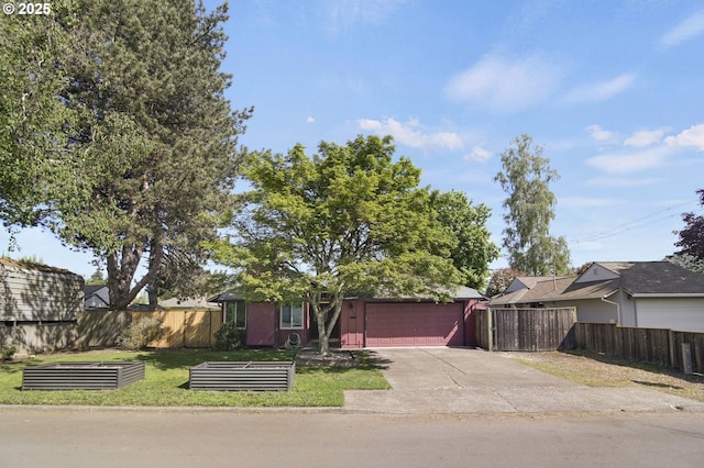 view of front facade featuring fence, an attached garage, concrete driveway, and a front lawn