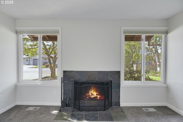 room details featuring visible vents, carpet floors, and a fireplace