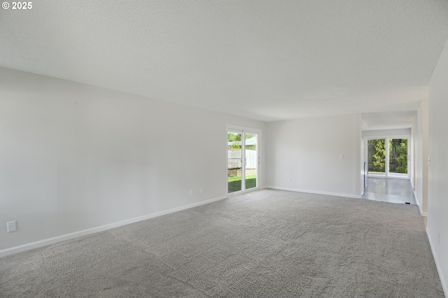 carpeted empty room featuring baseboards