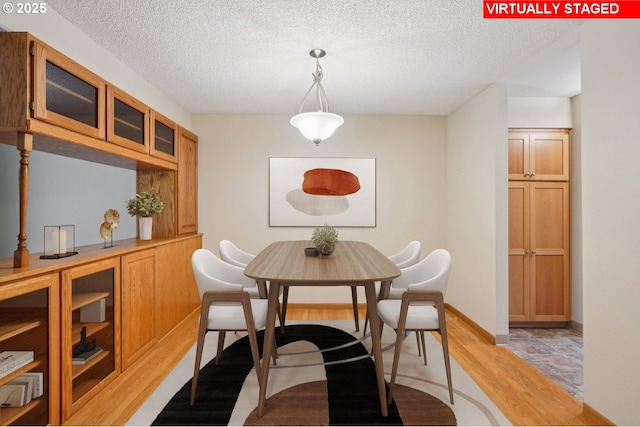 1200 NE Territorial Rd Unit 83, Canby, OR 97013 - dining space with light wood-style flooring, a textured ceiling, and baseboards