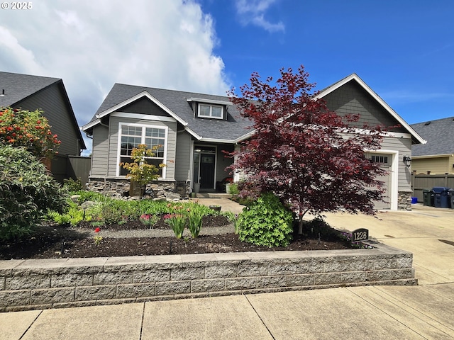 craftsman-style home with stone siding, concrete driveway, roof with shingles, and a garage