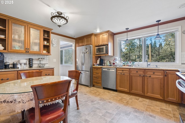 kitchen with sink, decorative light fixtures, appliances with stainless steel finishes, and tasteful backsplash