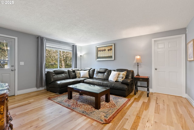 living room with a textured ceiling and light hardwood / wood-style flooring