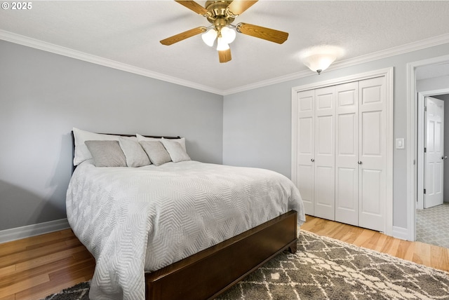 bedroom featuring ceiling fan, wood-type flooring, a closet, and ornamental molding